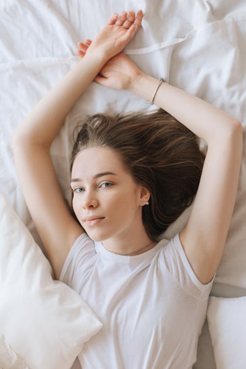Free A Woman Lying Comfortably in Bed Stock Photo