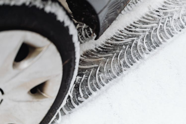 A Vehicle Leaving Tire Tracks On Snow Covered Ground