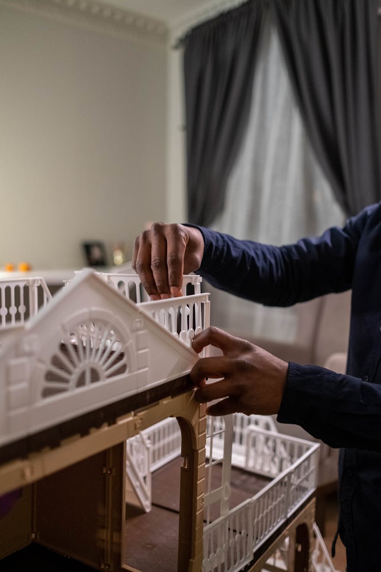 A Person Building A Dollhouse