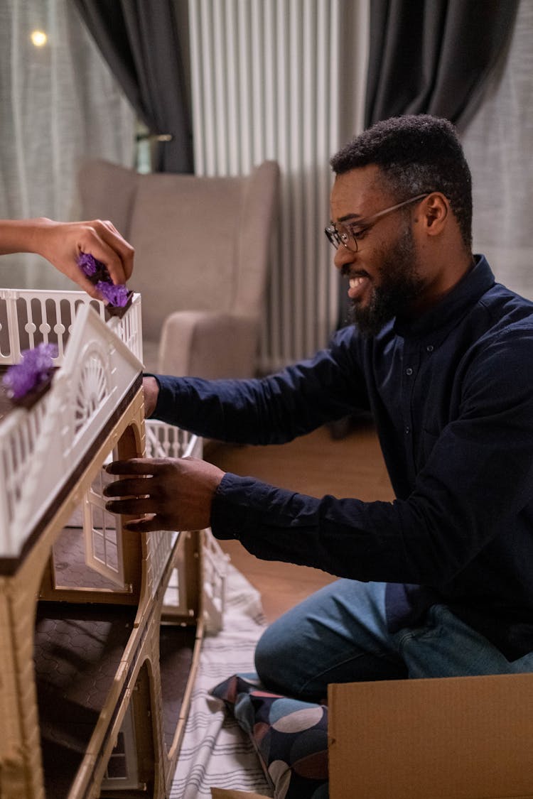 A Man Assembling The Dollhouse