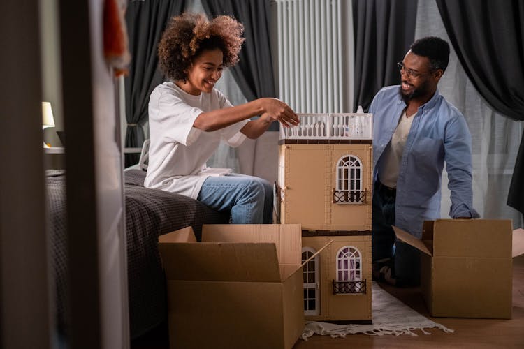 A Father And Daughter Playing The Dollhouse Together 