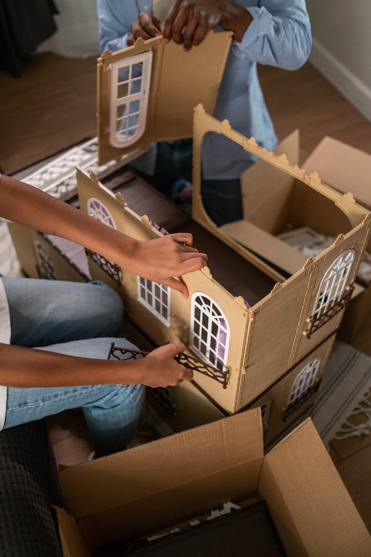 A Father And Daughter Assembling The Dollhouse Together