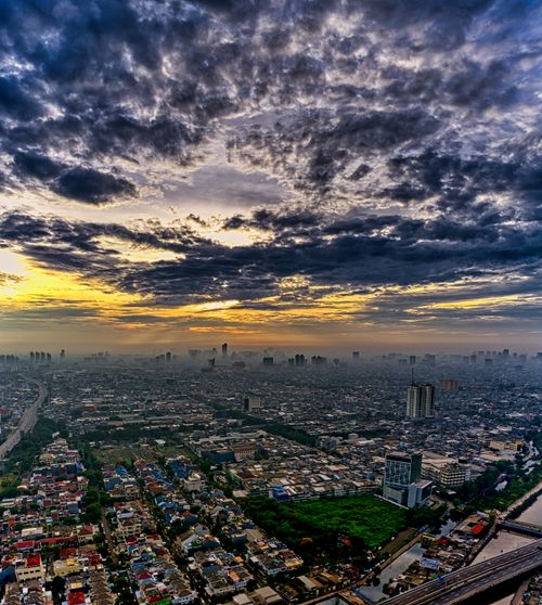 Free Aerial view of Jakarta, Indonesia, showcasing urban sprawl under a dramatic sunset sky. Stock Photo