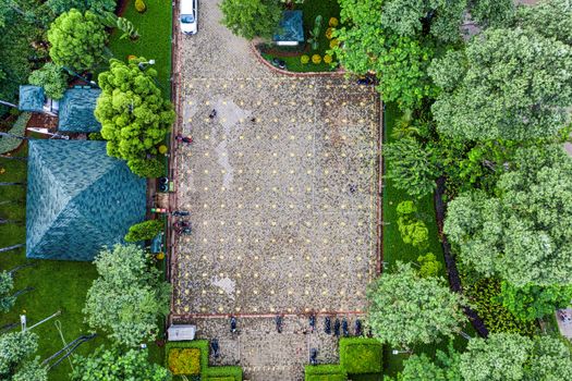 Aerial view of a tree-lined parking area in Jakarta, showcasing greenery and parked motorbikes.
