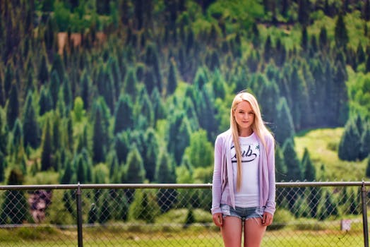 Portrait of a young woman by a fence with mountainous backdrop in Silverton, Colorado.