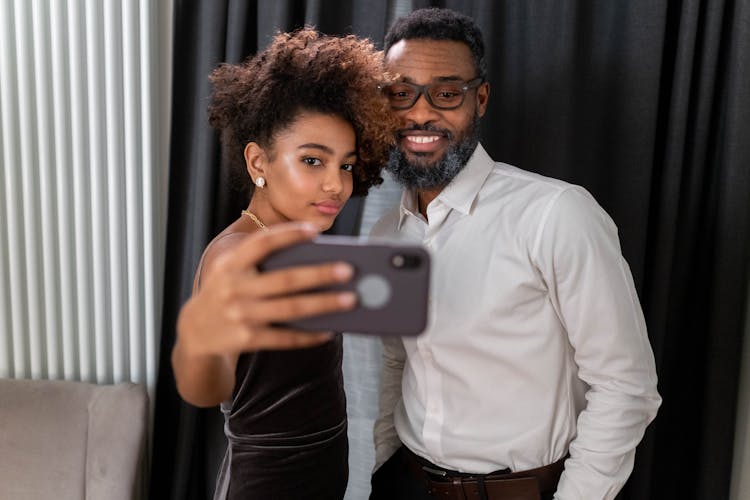 A Mature Man And A Young Woman Taking Selfie