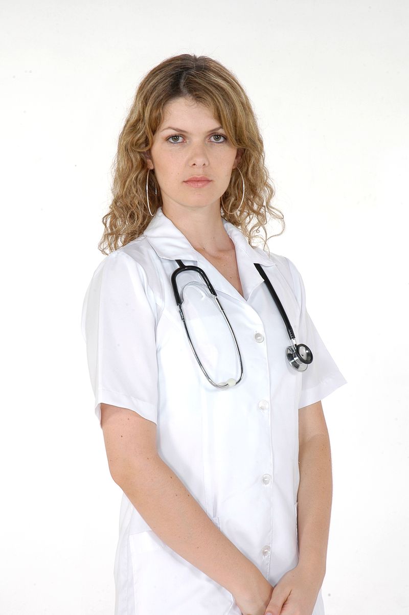 A smiling Thistledown caregiver in white scrubs
