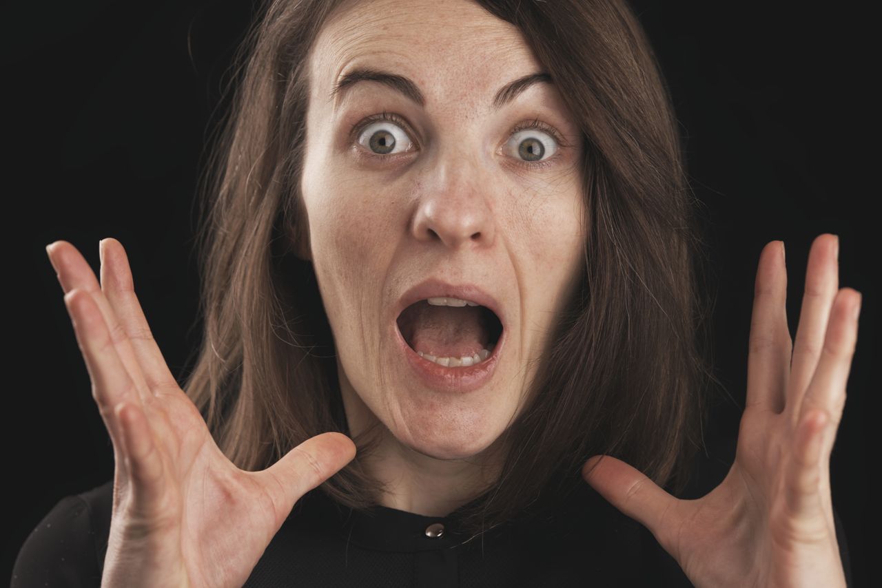 close up of a woman expressing shock and surprise with wide eyes and o