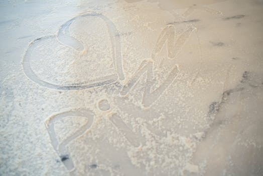 Heart shape and word 'pizza' drawn in flour on a marble table, symbolizing love for cooking.