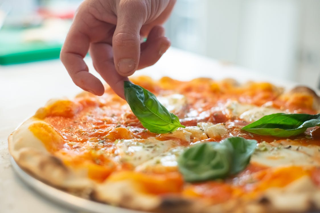 Free Person Put Basil Leaf on Pizza 