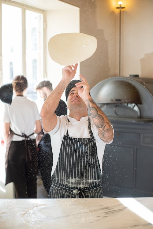 Chef Spinning Dough in a Pizzeria