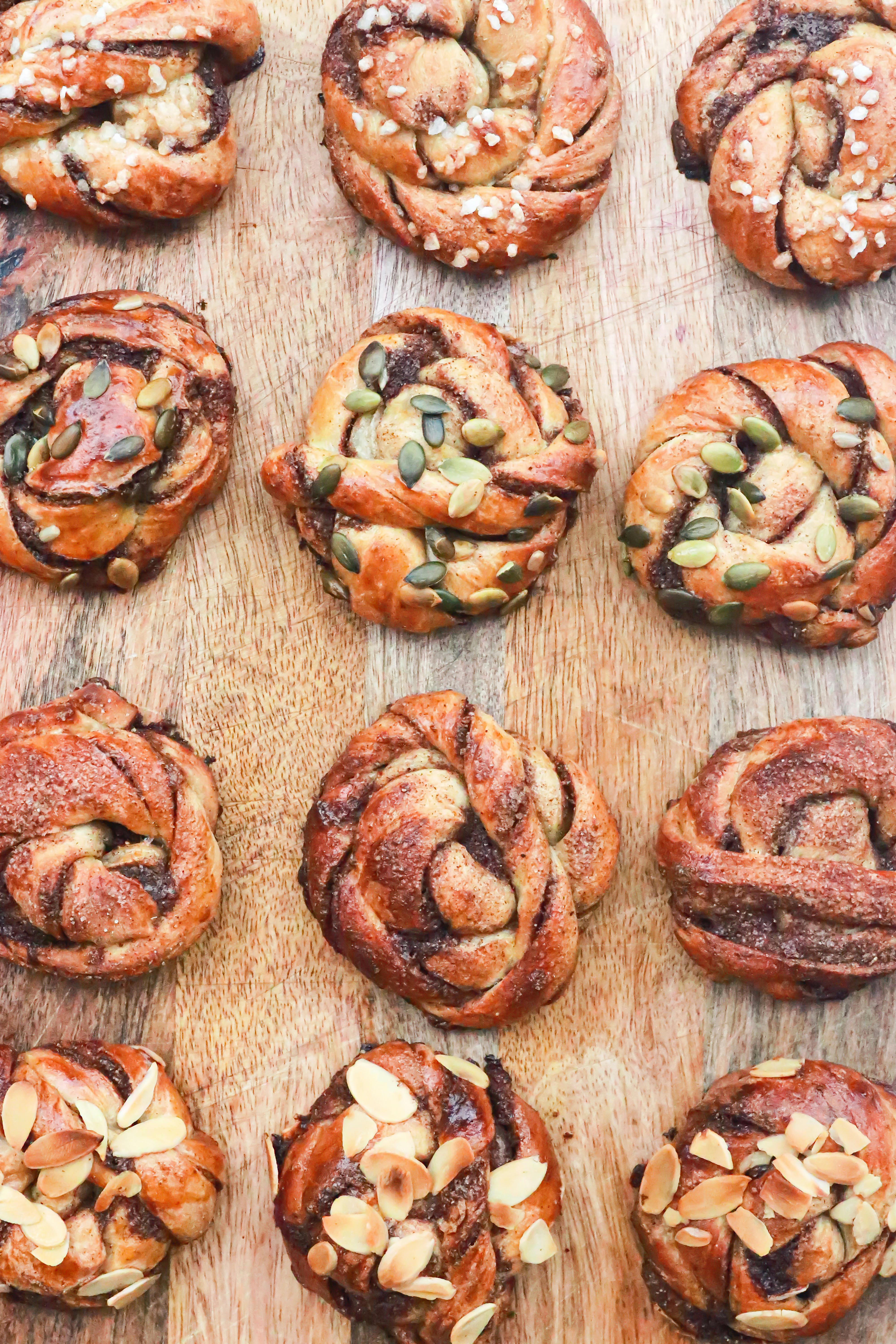 sweet buns with grains arranged on wooden board