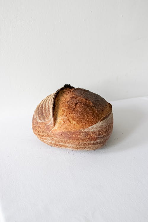 Freshly baked golden loaf on white surface