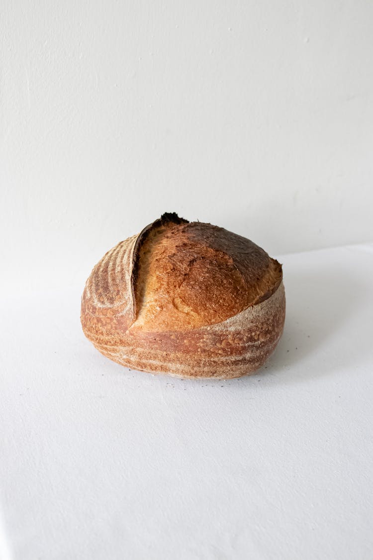 Freshly Baked Golden Loaf On White Surface