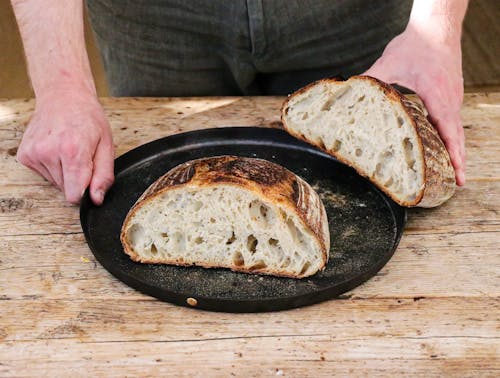 Free Baker with cut loaf on plate Stock Photo