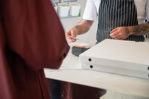 Free Chef receiving card payment for pizza order in a restaurant. Stock Photo