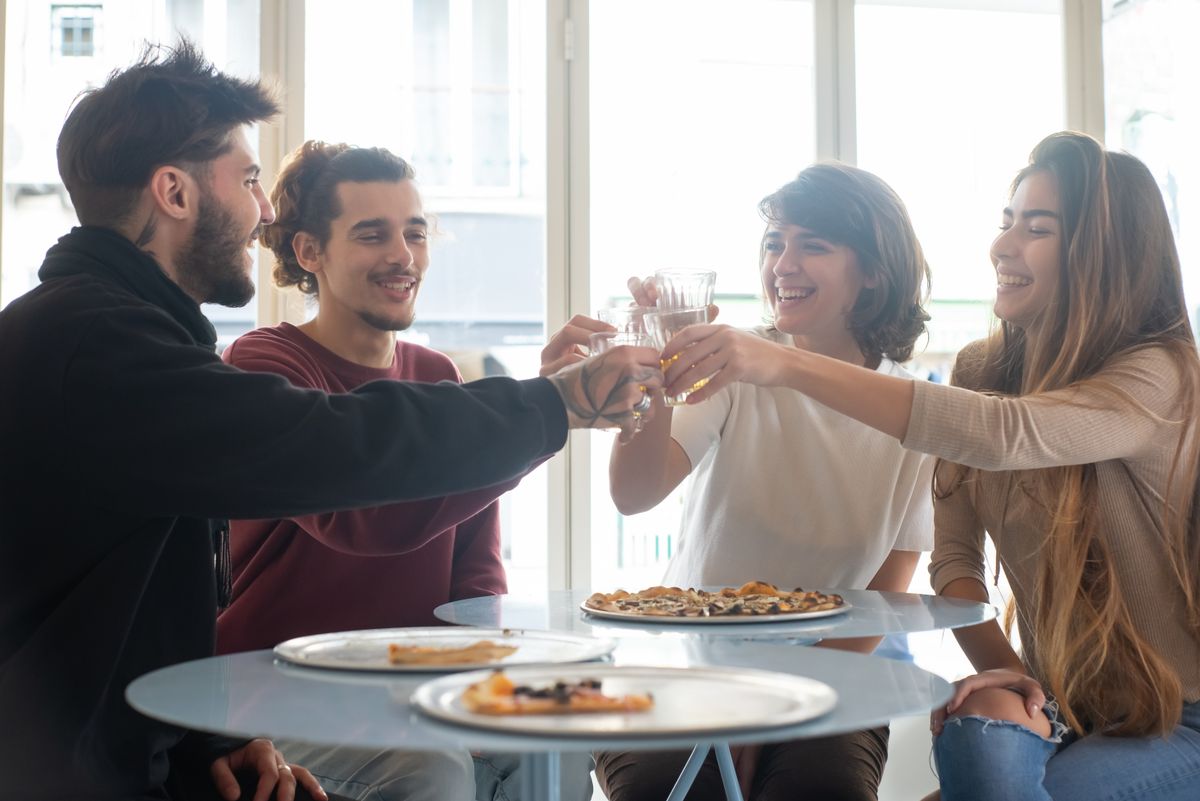 A group of friends making a glasses toast together at a table