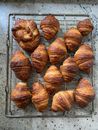 From above of many fresh baked sweet croissants served on metal stand after baking on marble table in light kitchen
