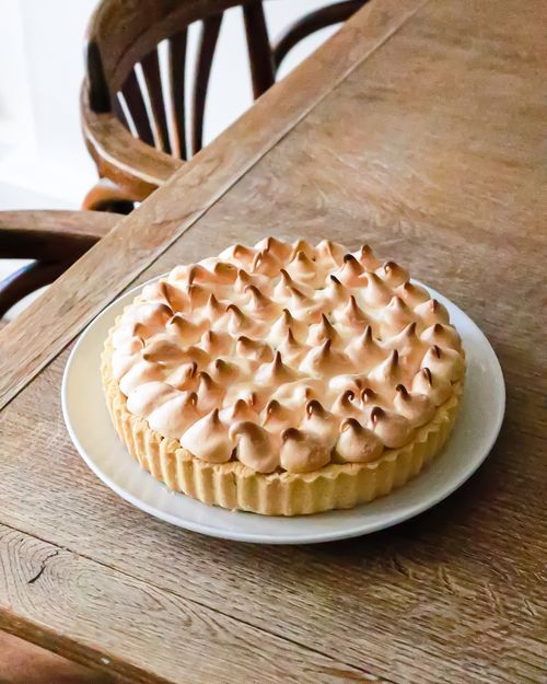 Free From above of tasty lemon tart with shortcrust pastry and burnt meringue and served on plate on table in kitchen Stock Photo