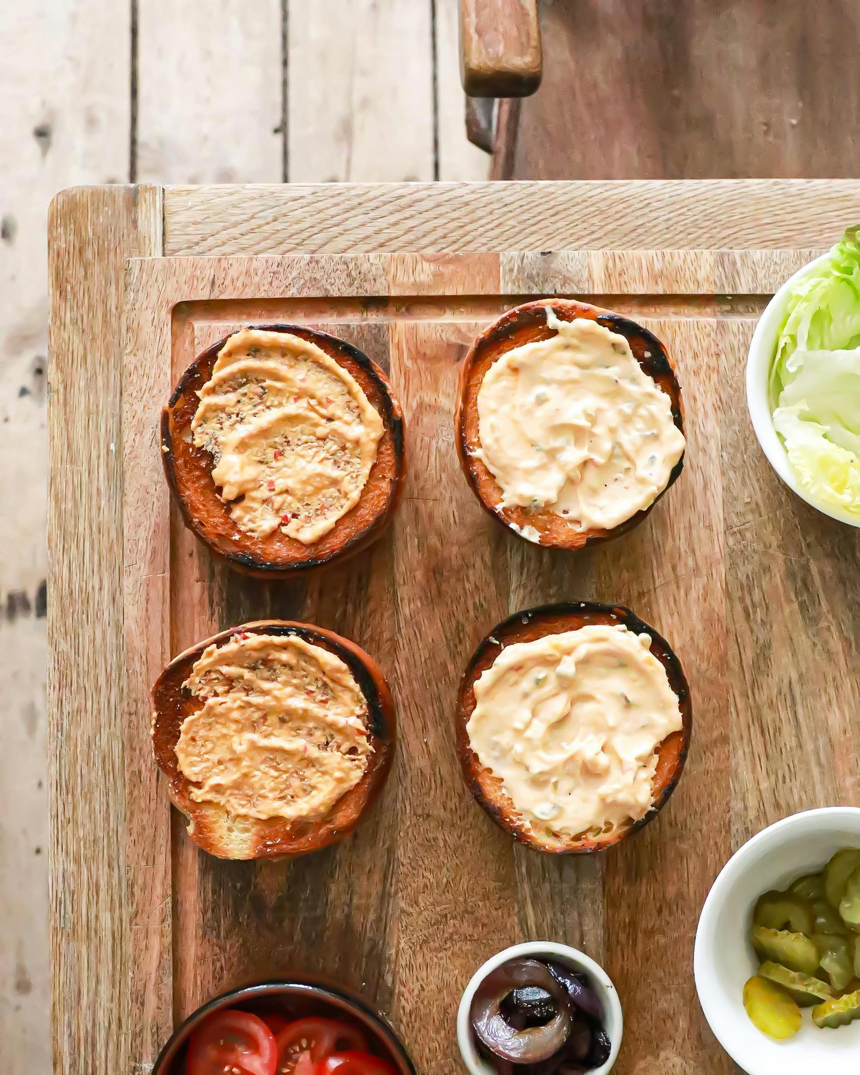 burger buns with sauces on table