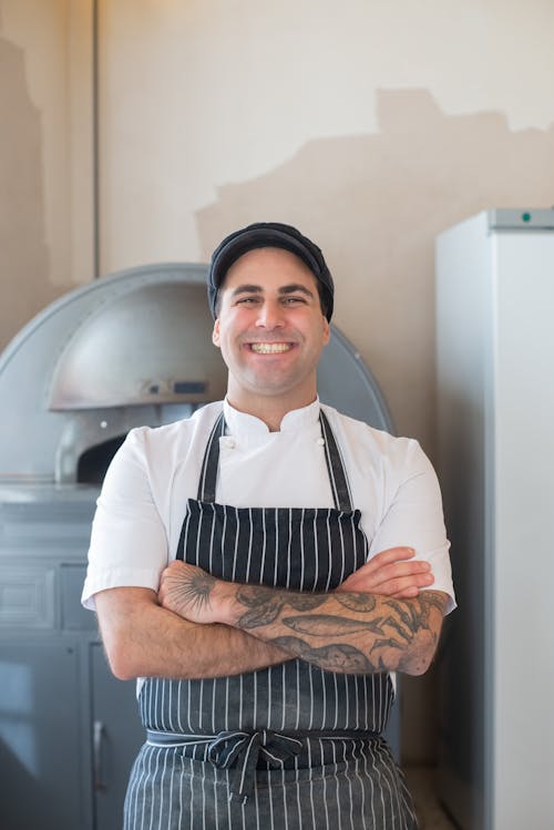 Free A Man Wearing a Black and White Striped Apron and a Black Hat Stock Photo