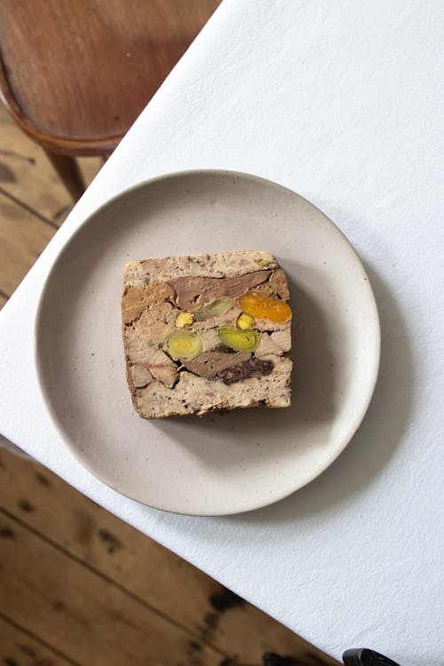 Top view of appetizing meatloaf with fresh vegetables served in ceramic plate on table in restaurant