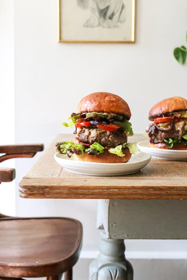 Delicious burgers with beef and veggies served on table