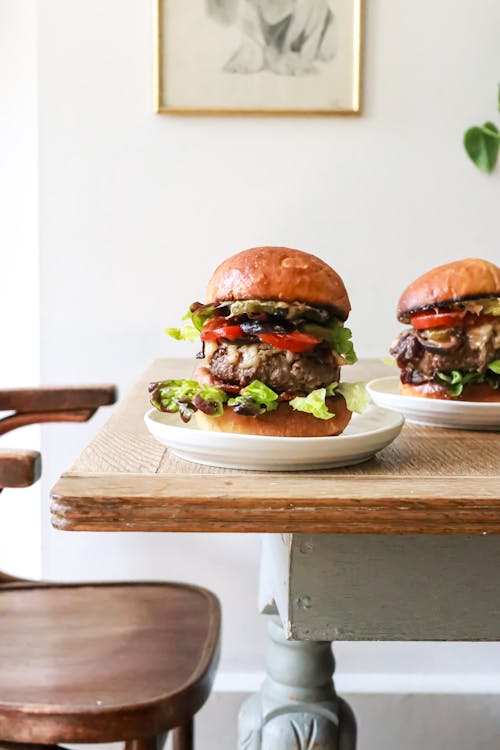Free Delicious burgers with beef and veggies served on table Stock Photo