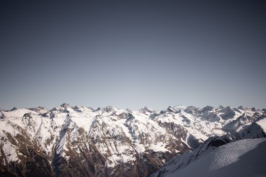 Beautiful snow-covered mountain range under a clear sky, showcasing stunning winter landscape.