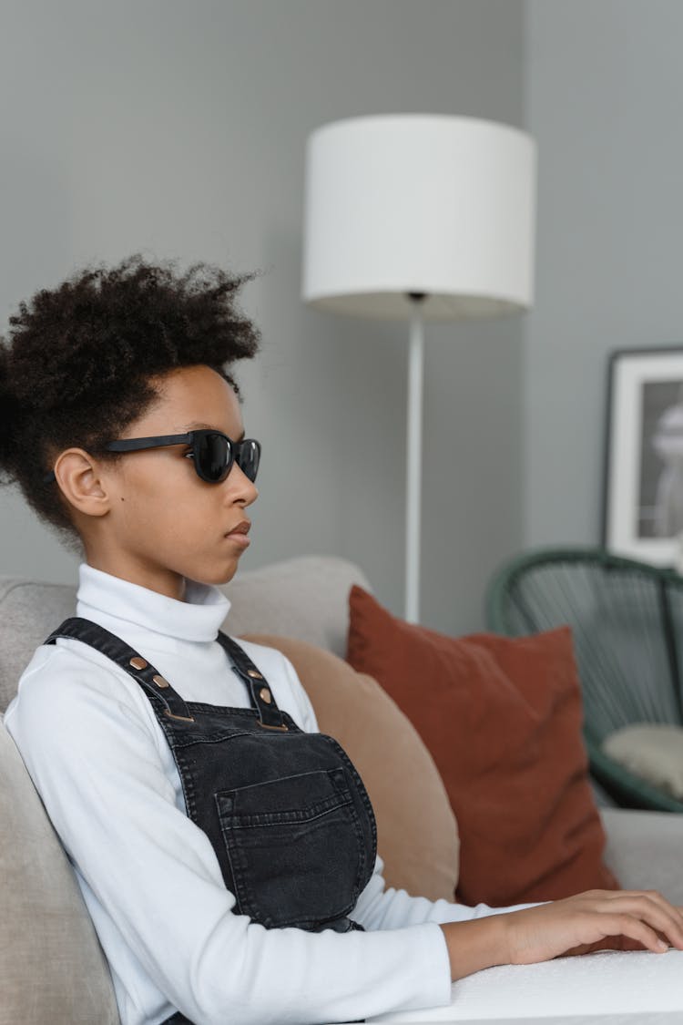 A Child In White Turtle Neck Shirt Wearing Black Sunglasses