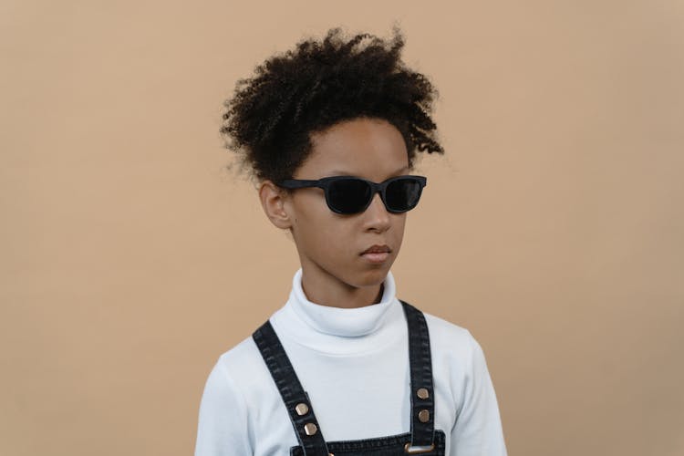 A Child In White Turtle Neck Shirt Wearing Black Sunglasses