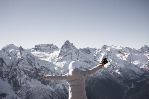 Free Back View of a Person Looking the Snow Mountains Stock Photo
