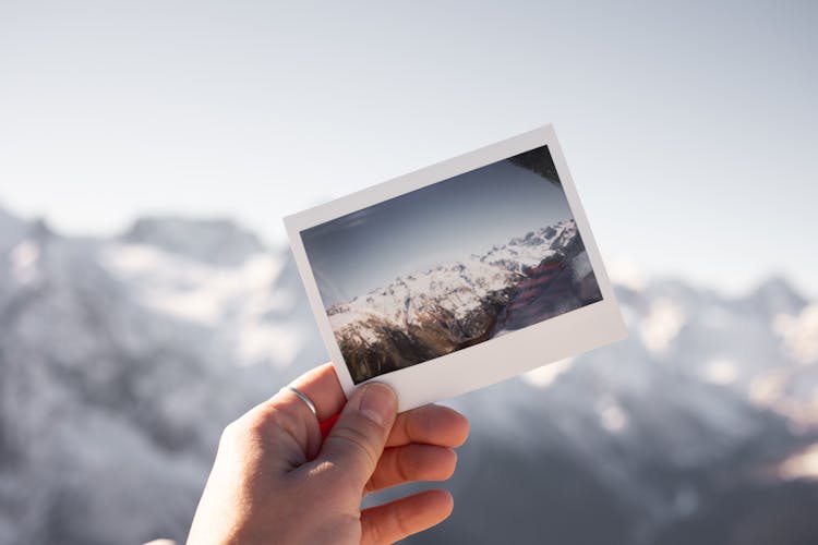 Person Holding Mountain Picture In Nature Landscape