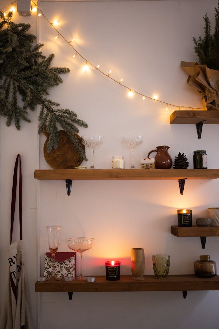 Wooden Shelves With Assorted Displays Under String Of Lights