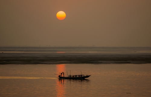 Silhouette of Boat on the Ocean during Sunset