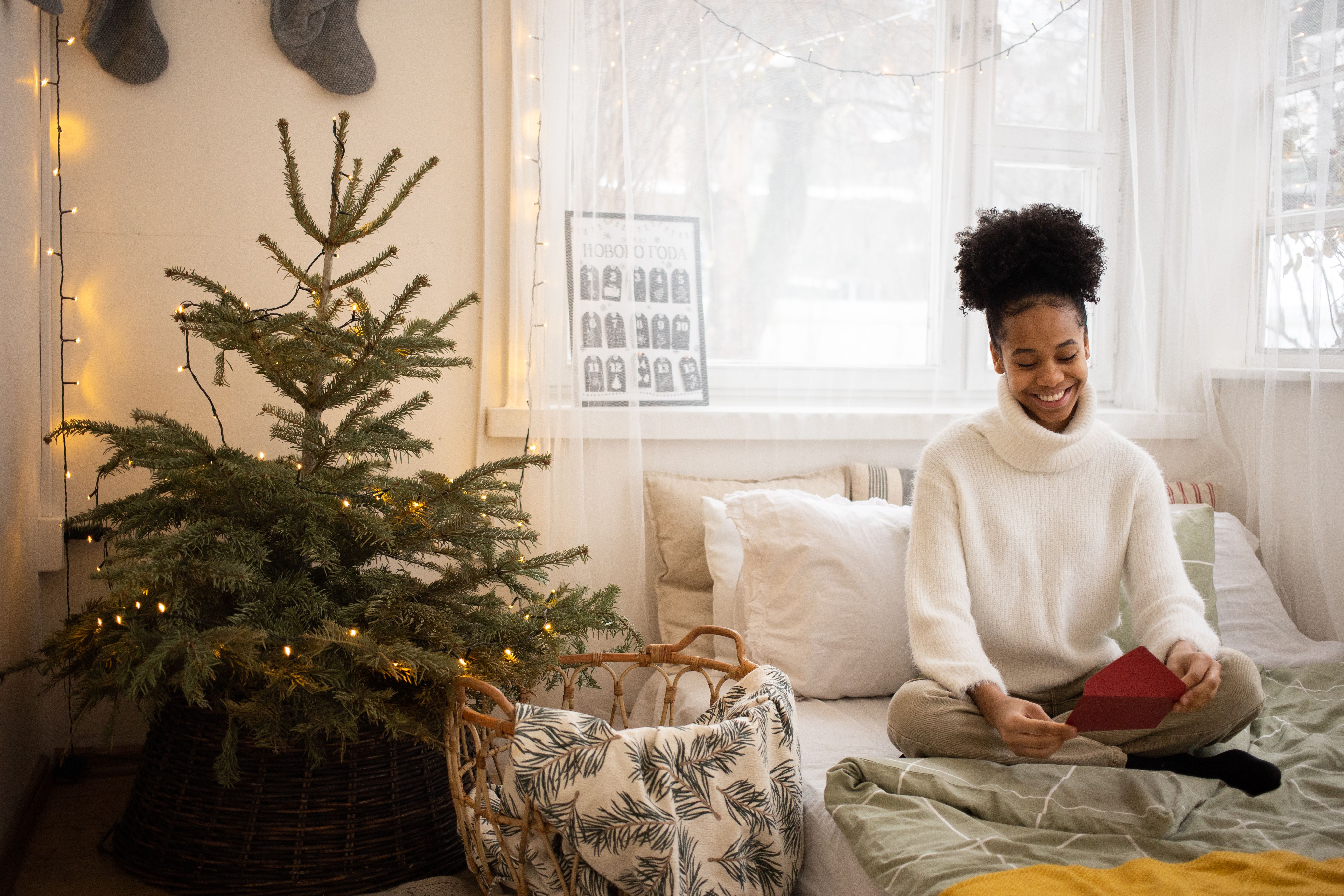 Woman opening beautifully wrapped Christmas gift with card — personalised Christmas morning moment