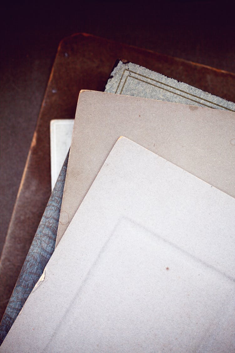 A Stack Of Old Papers On A Brown Board