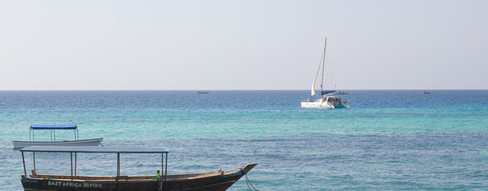 Peaceful seascape featuring sailboats on turquoise waters of Zanzibar, Tanzania.