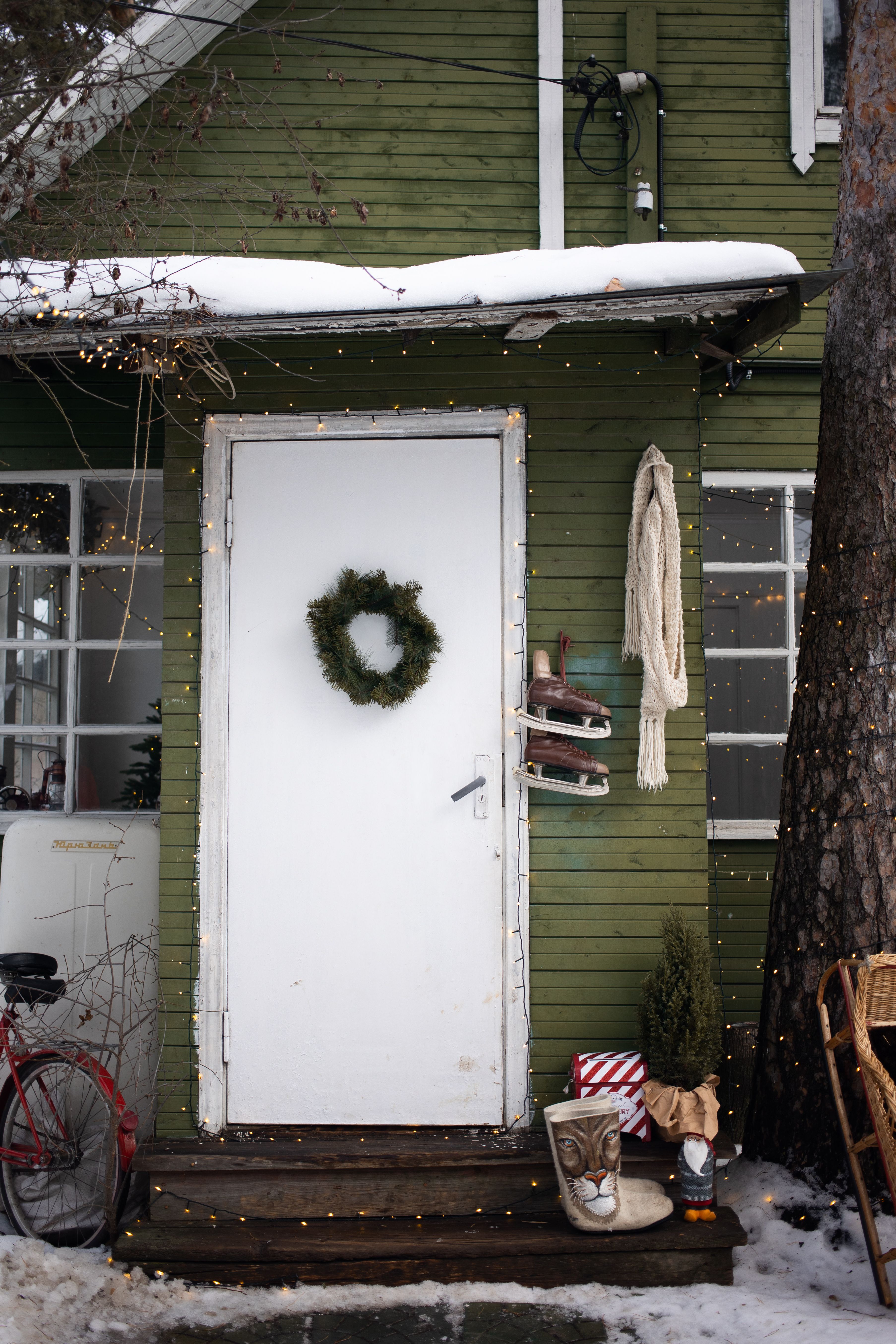 Charming porch with Christmas wreath and snowy scene captures winter holiday spirit.