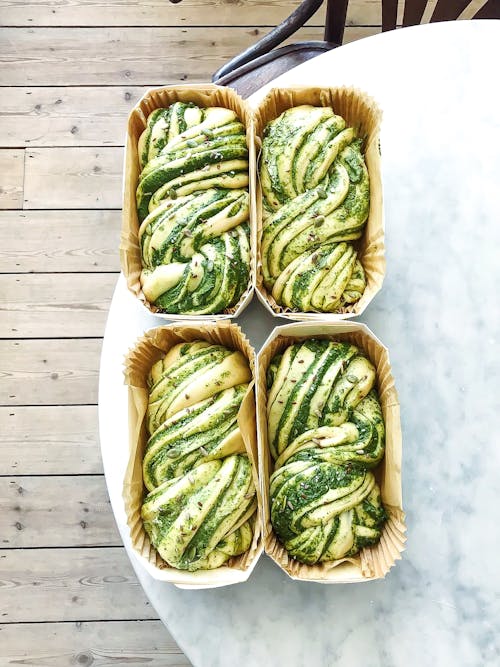 Raw bread with pesto in containers on table