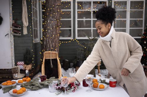 Free Woman decorating an outdoor table with oranges and festive decor during winter. Stock Photo