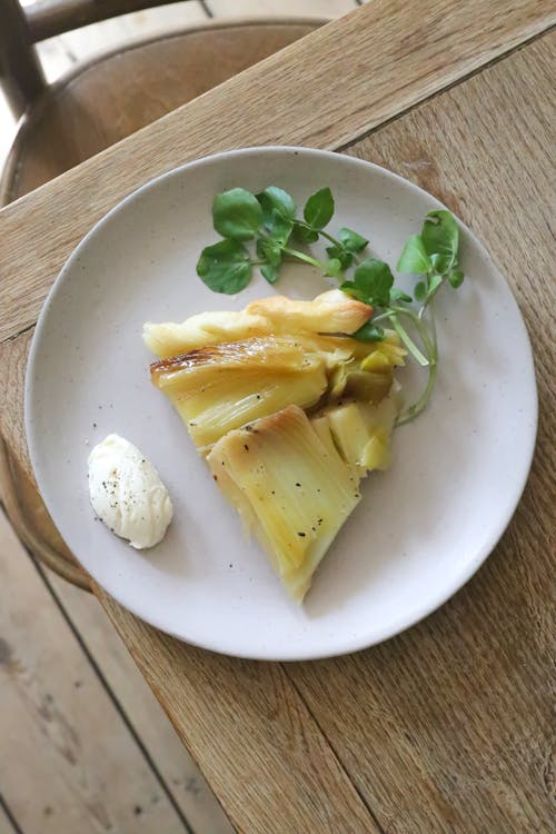 Rhubarb pie with herb and white cream on plate