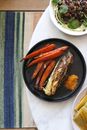 Delicious grilled carrot with corn cob in plate on table