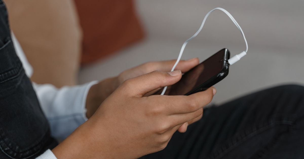 Person using a phone with a black-and-white screen, looking relaxed