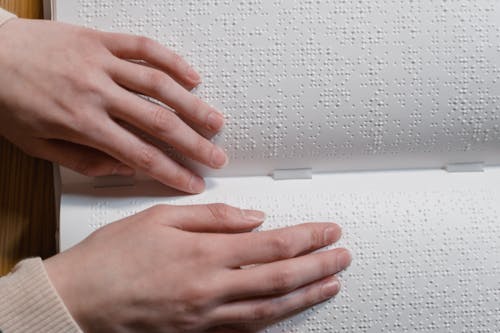 Close-Up Shot of a Person Touching a Braille 