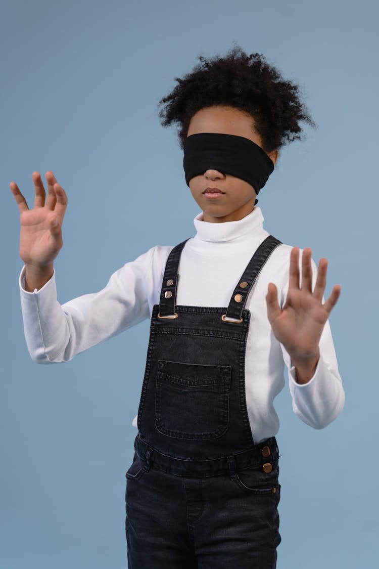 A Child With Blindfold Feeling The Surroundings