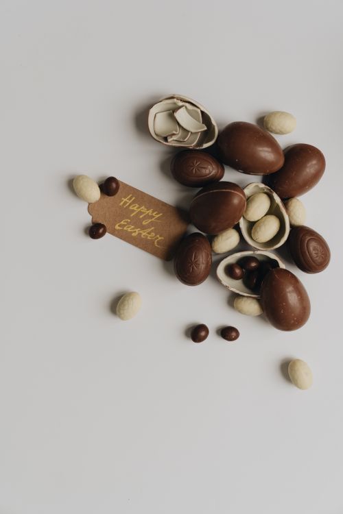 Free A collection of chocolate Easter eggs on a white background with a Happy Easter tag. Stock Photo