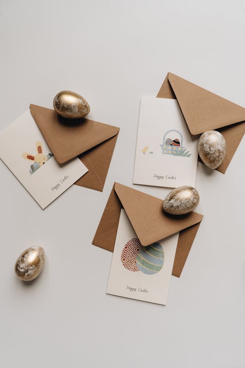 Easter Eggs and Greeting Cards with Envelopes on a White Surface
