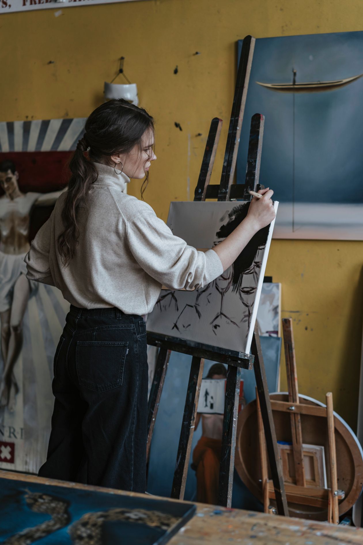 A young artist restoring a canvas in a heritage studio