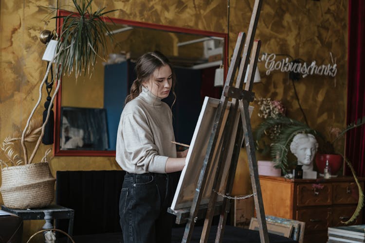 A Woman Painting On A Canvas 